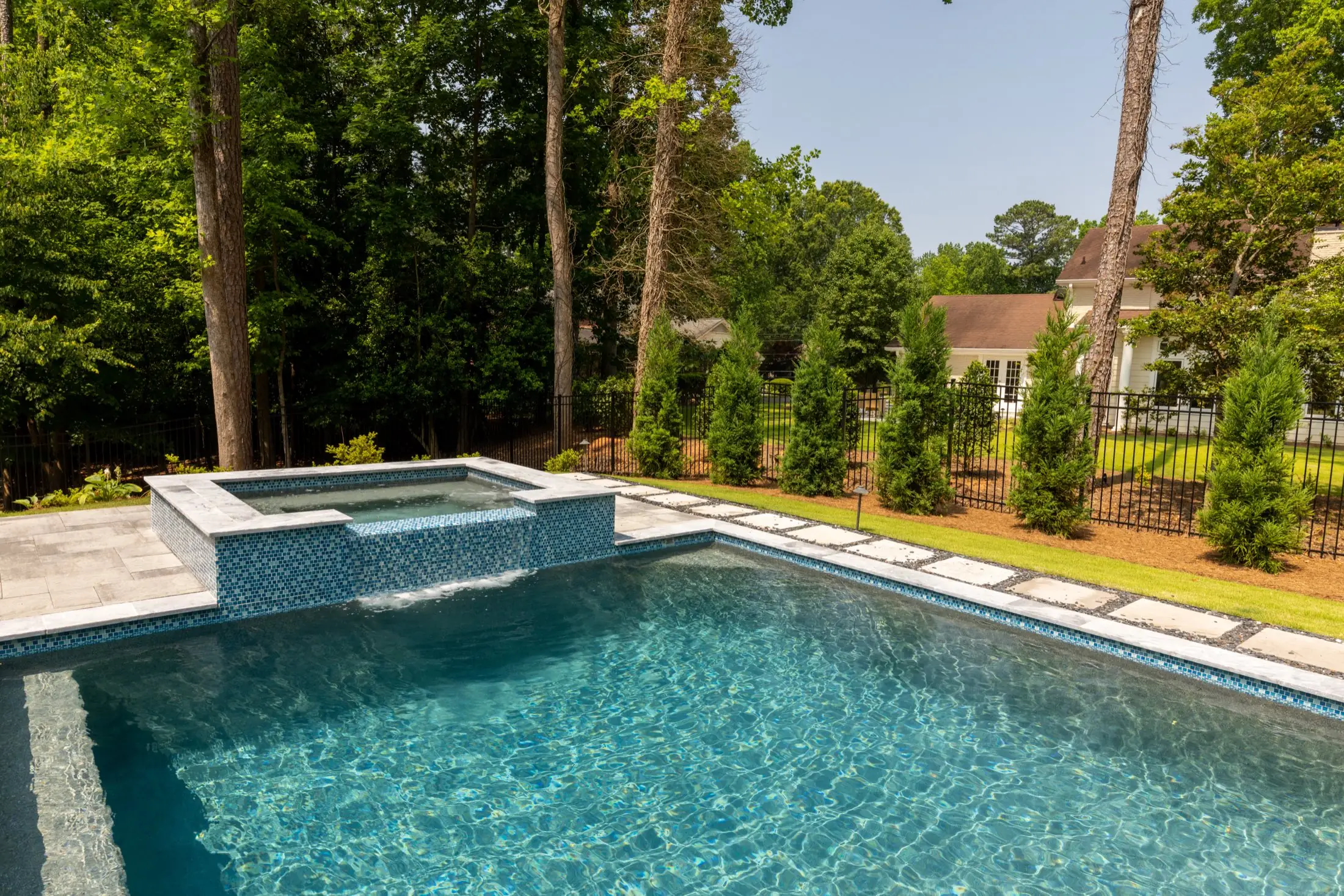 Raised spa with tile spillway over a geometric pool at the Goldstein project in Dunwoody
